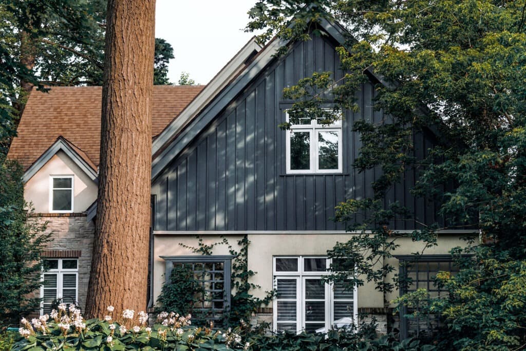 Beautiful modern home with dark siding nestled among trees